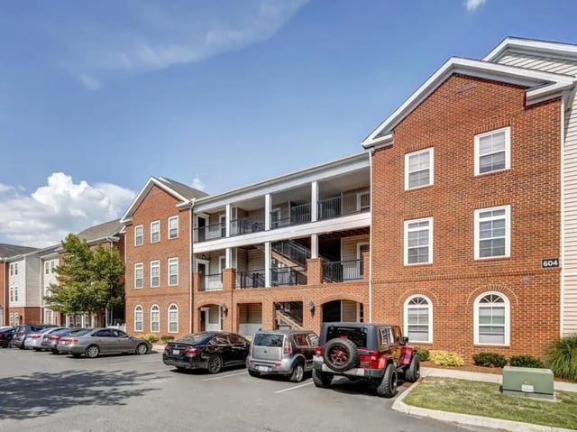 Brick building with parking lot cars exterior at The Province Greensboro in Greensboro Student Accommodation