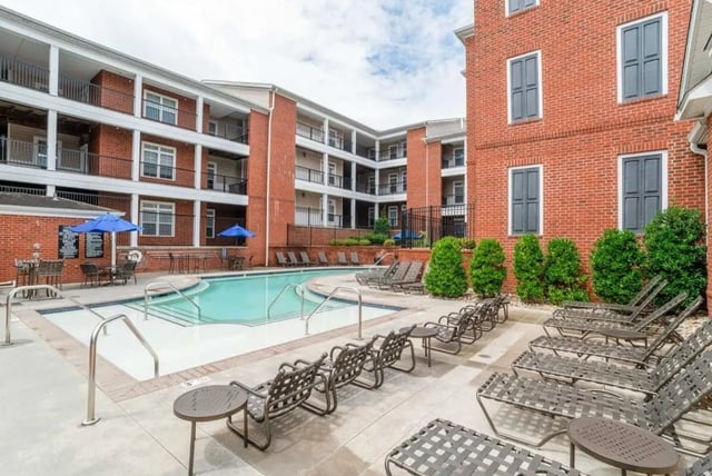 Pool area with lounge chairs and seating exterior at The Province Greensboro in Greensboro Student Accommodation