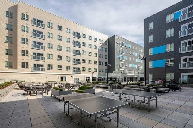 Ping pong tables seating dining tables courtyard exterior at Theory Syracuse in Syracuse Student Accommodation