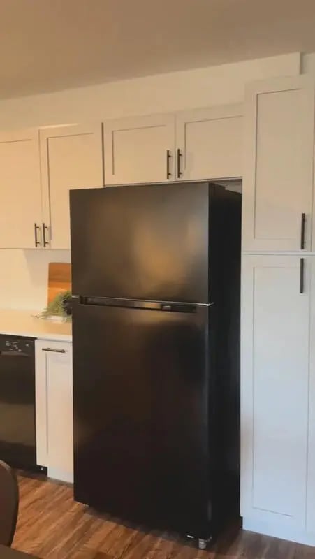 Black refrigerator white cabinets wooden floor kitchen at Altitude Baton Rouge | Apartment Complex in Baton Rouge Student Accommodation