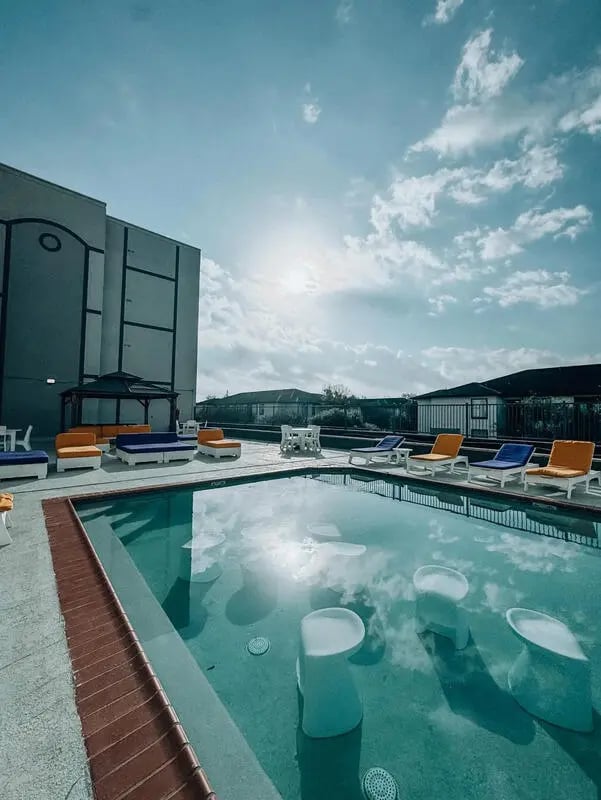 Pool with submerged stools lounge chairs outdoor living area at Altitude Baton Rouge | Apartment Complex in Baton Rouge Student Accommodation