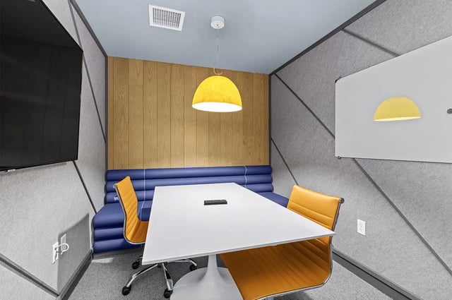 Table chairs TV and whiteboard meeting room at The Dean Campustown in Champaign Student Accommodation