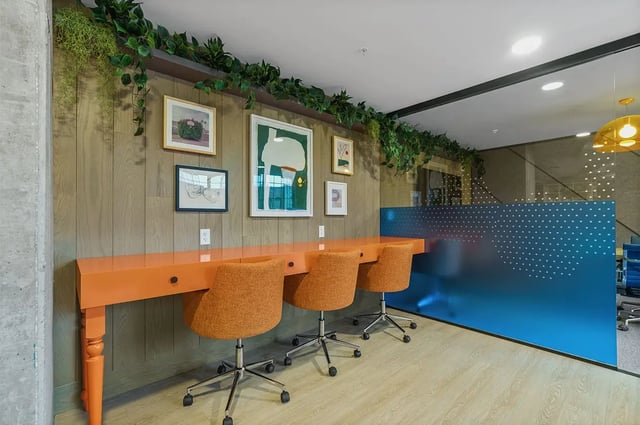Orange desks and chairs with artwork study area at The Dean Campustown in Champaign Student Accommodation