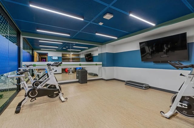 Spin bikes mirror and step platforms gym at The Dean Campustown in Champaign Student Accommodation