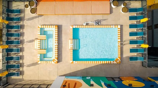 Pool loungers and pools with orange trim exterior at The Dean Campustown in Champaign Student Accommodation
