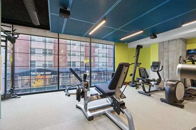 Weight bench stationary bikes climbing machine gym at The Dean Campustown in Champaign Student Accommodation