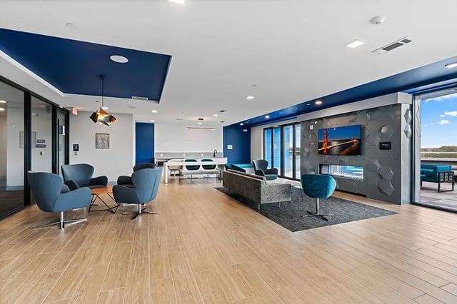 Blue armchairs sofa fireplace TV living area living room at Bixby Kennesaw in Kennesaw Student Accommodation