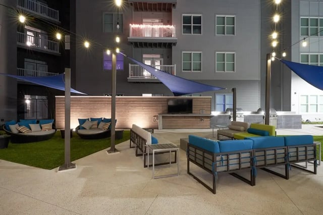 Outdoor lounge seating with grills and television living area at Bixby Kennesaw in Kennesaw Student Accommodation