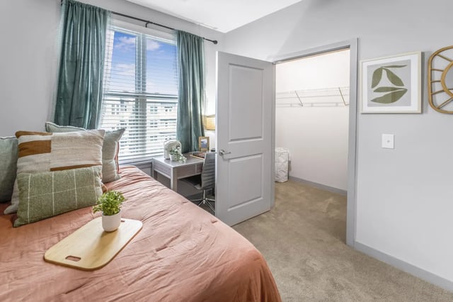 Bed with pillows desk chair and open closet bedroom at Bixby Kennesaw in Kennesaw Student Accommodation