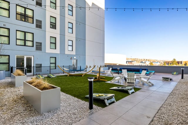 Hammock cornhole tables chairs outdoor recreation area at The Dean Reno in Reno Student Accommodation