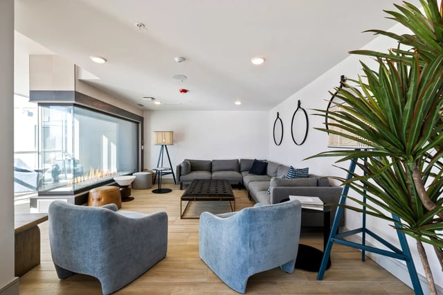 Modern living room with sectional sofa fireplace and chairs living room at The Dean Reno in Reno Student Accommodation