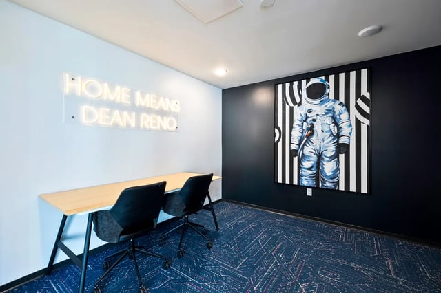 Desk chairs neon sign astronaut painting study area at The Dean Reno in Reno Student Accommodation