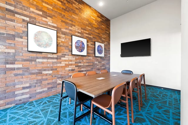 Large table with chairs and TV meeting area at The Dean Reno in Reno Student Accommodation