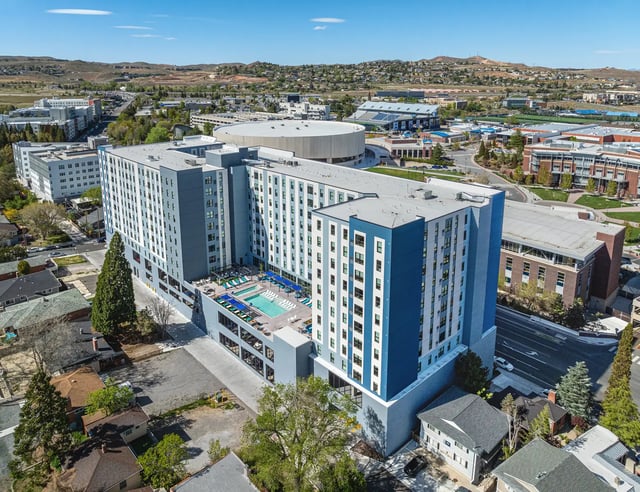 Modern apartment building with pool and lounge chairs exterior at The Dean Reno in Reno Student Accommodation