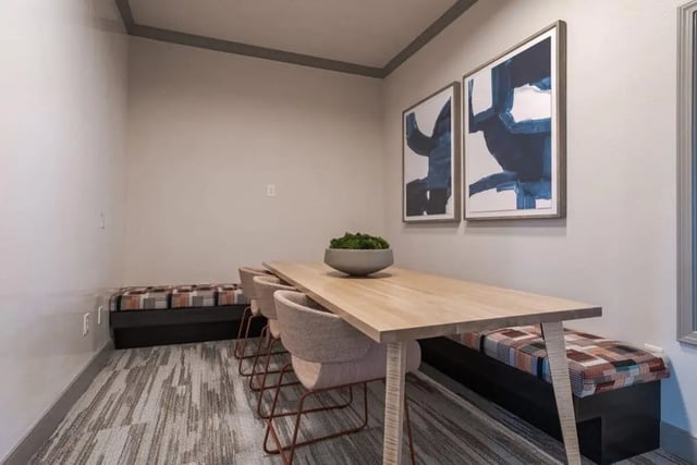 Long table chairs patterned bench artwork living room at Crossing Place in College Station Student Accommodation