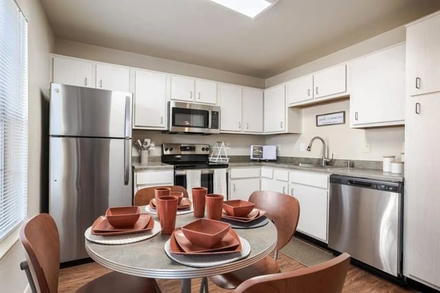 Dining table chairs stainless steel refrigerator kitchen at Crossing Place in College Station Student Accommodation