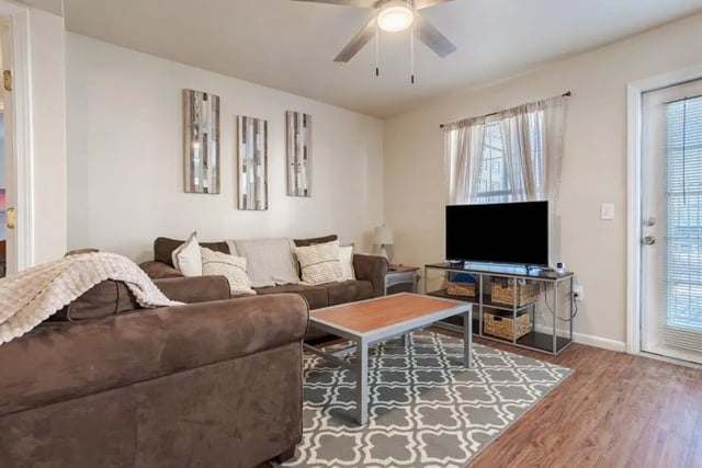 Brown sofa with patterned rug and TV living room at Crossing Place in College Station Student Accommodation