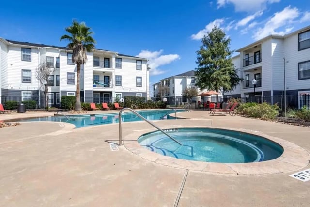 Pool and hot tub with apartment buildings exterior at Crossing Place in College Station Student Accommodation