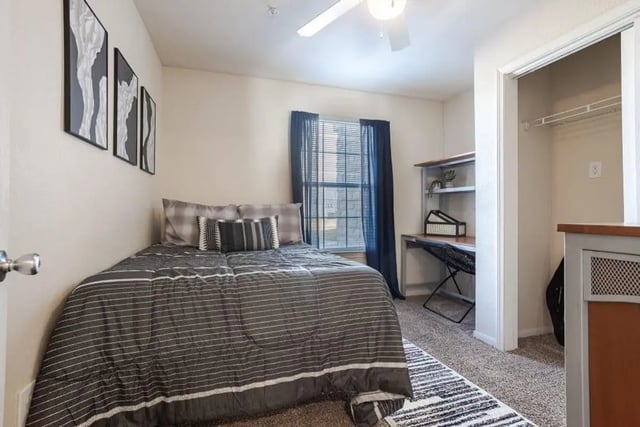 Bed desk framed art closet and ceiling fan bedroom at Crossing Place in College Station Student Accommodation