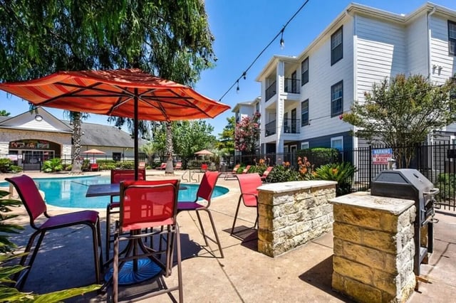 Outdoor seating umbrellas and grill exterior at Crossing Place in College Station Student Accommodation