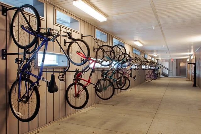 Wall mounted bicycles in covered walkway exterior at The Q'ube in Springfield Student Accommodation