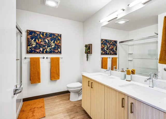Double sinks toilet artwork towels and shower bathroom at Theory U District in Seattle Student Accommodation
