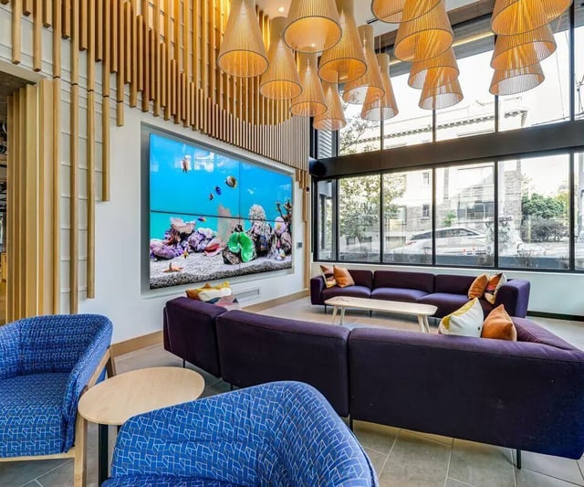 Sofa chairs large screen aquarium living room at Theory U District in Seattle Student Accommodation