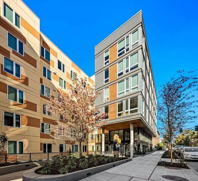 Modern building with trees sidewalk and cars exterior at Theory U District in Seattle Student Accommodation