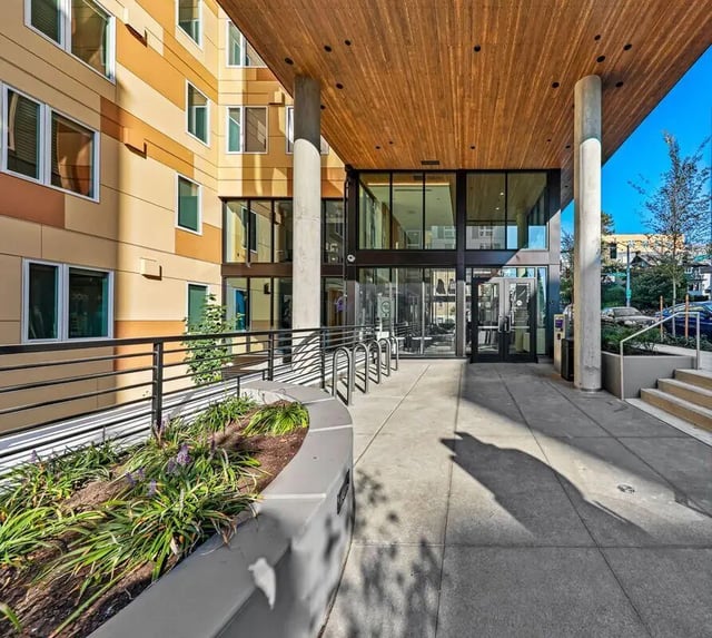 Bike racks and planters outside modern building exterior at Theory U District in Seattle Student Accommodation
