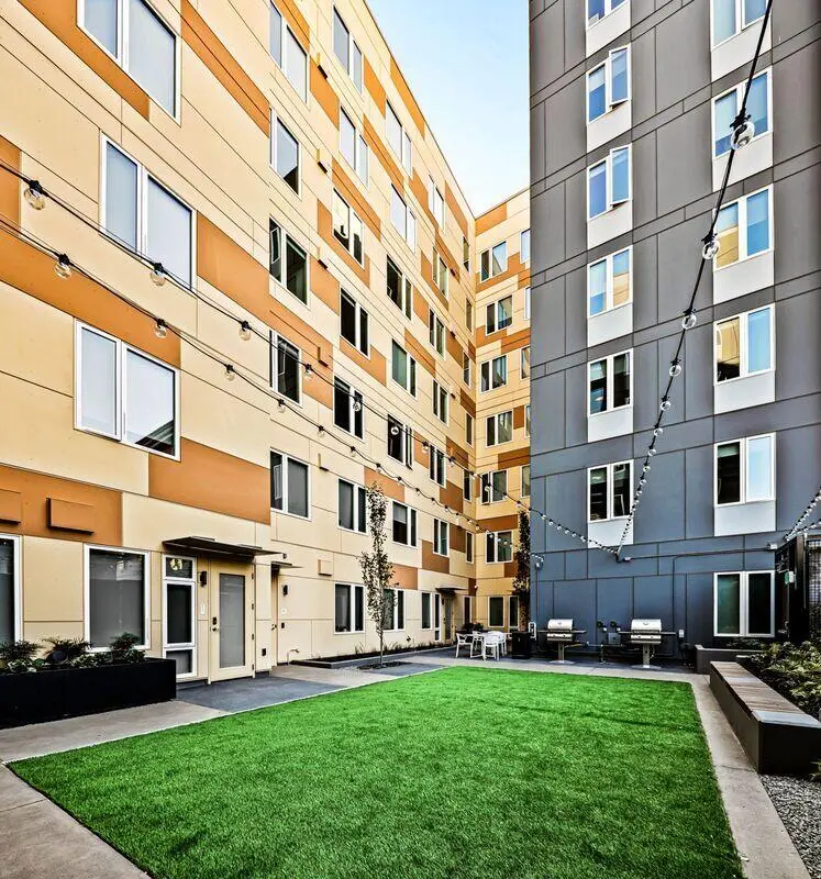 Courtyard with grass barbecues and seating exterior at Theory U District in Seattle Student Accommodation