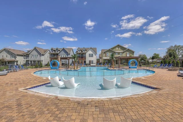 Swimming pool with white lounge chairs and housing exterior at Cobalt Row in Murfreesboro Student Accommodation