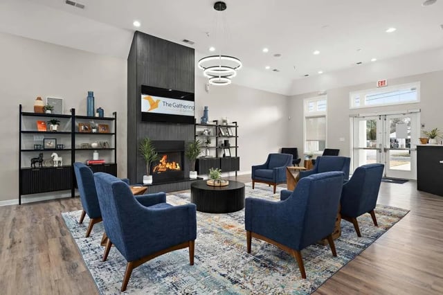 Blue armchairs fireplace and coffee table living room at The Gathering in Salisbury Student Accommodation