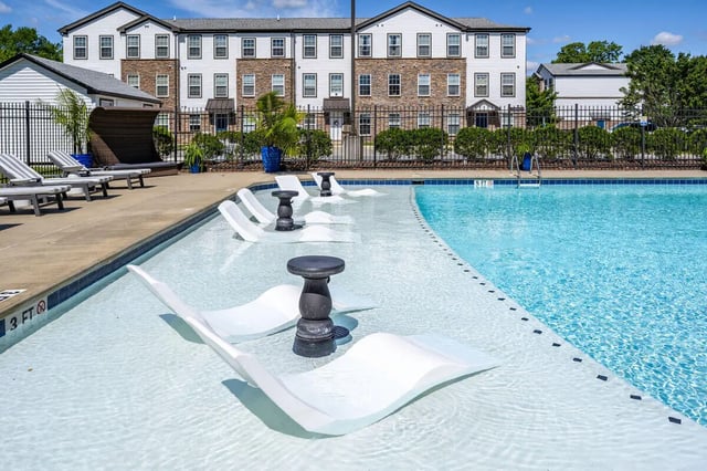 White lounge chairs in shallow pool near building exterior at The Gathering in Salisbury Student Accommodation