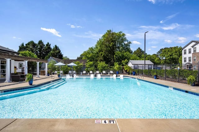 Pool with lounge chairs umbrellas and buildings exterior at The Gathering in Salisbury Student Accommodation