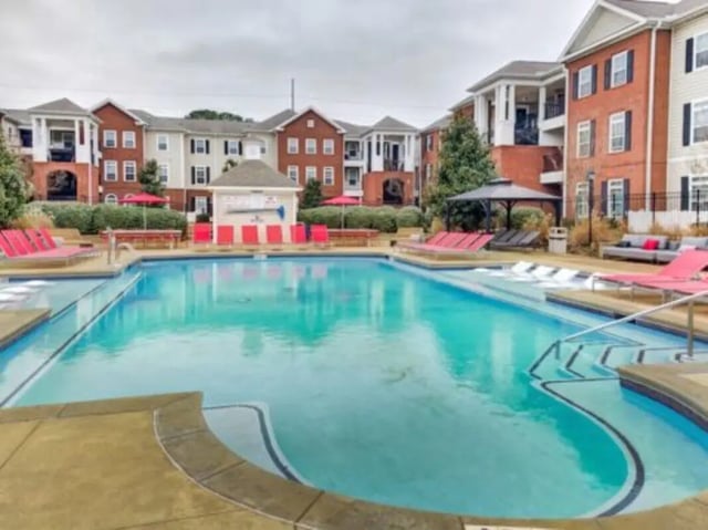 Pool with lounge chairs and buildings exterior at East Edge in Tuscaloosa Student Accommodation