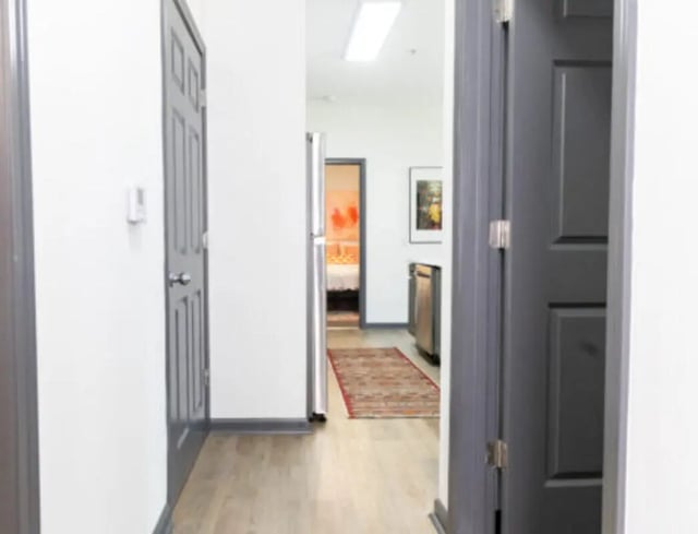 Hallway with doors and visible kitchen area hallway at East Edge in Tuscaloosa Student Accommodation