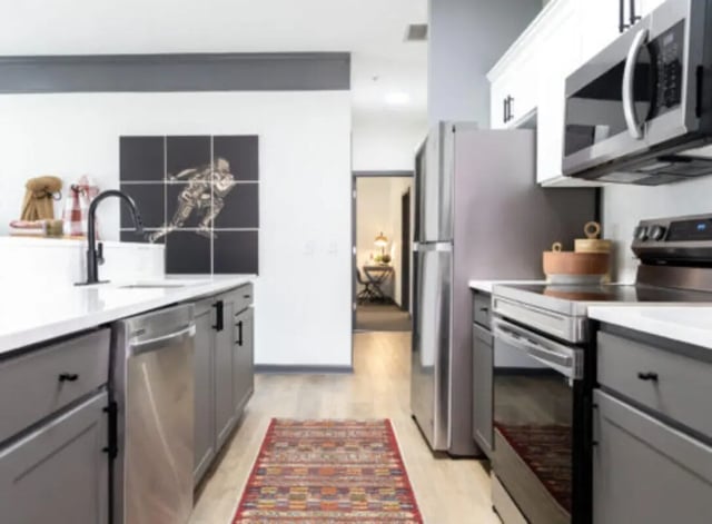 Modern kitchen with stainless steel appliances and artwork at East Edge in Tuscaloosa Student Accommodation