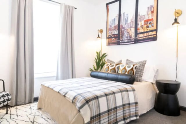 Bed pillows art plant black side table bedroom at East Edge in Tuscaloosa Student Accommodation