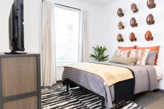 Bed with pillows and football decor bedroom at East Edge in Tuscaloosa Student Accommodation
