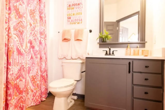 Toilet vanity mirror and pink shower curtain bathroom at East Edge in Tuscaloosa Student Accommodation