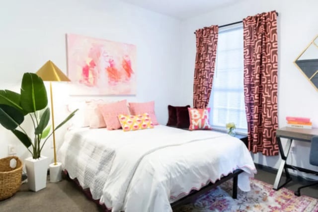 Bed pillows artwork curtains desk and rug bedroom at East Edge in Tuscaloosa Student Accommodation