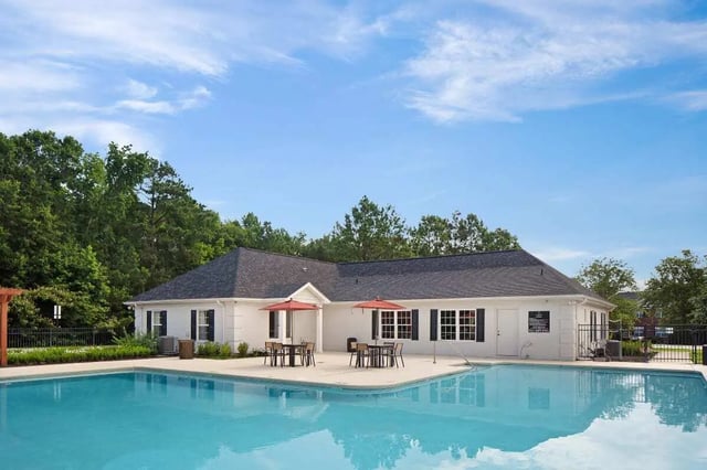 Poolside building with tables umbrellas exterior at The George in Statesboro Student Accommodation