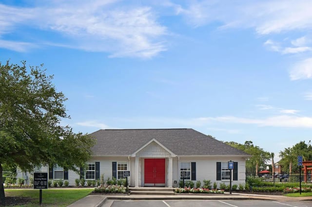 White building red doors manicured landscaping exterior at The George in Statesboro Student Accommodation