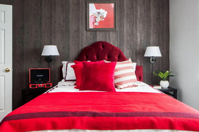Red velvet headboard bed pillows artwork bedroom at The George in Statesboro Student Accommodation