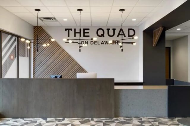 Modern reception desk logo computers and light fixtures lobby at The Quad On Delaware in Minneapolis Student Accommodation