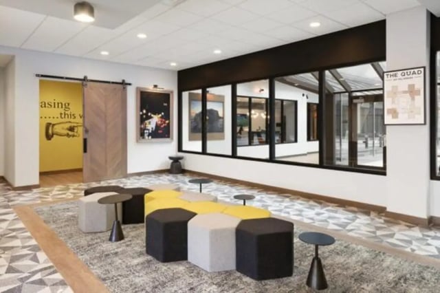 Hexagonal seating area with yellow and grey stools communal area at The Quad On Delaware in Minneapolis Student Accommodation
