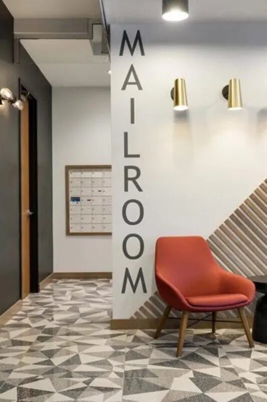 Mailroom with chair and mailboxes Interior at The Quad On Delaware in Minneapolis Student Accommodation