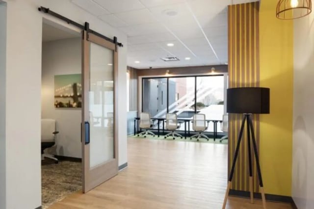 Glass barn door leading to meeting room with chairs and tables at The Quad On Delaware in Minneapolis Student Accommodation