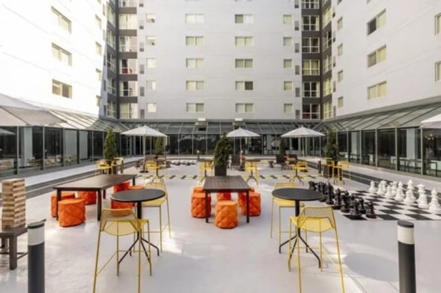 Outdoor seating and giant chess board exterior at The Quad On Delaware in Minneapolis Student Accommodation