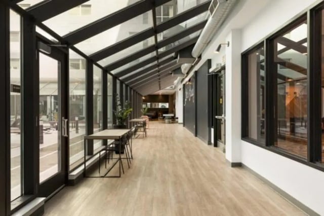 Modern walkway with tables chairs and plants common area at The Quad On Delaware in Minneapolis Student Accommodation